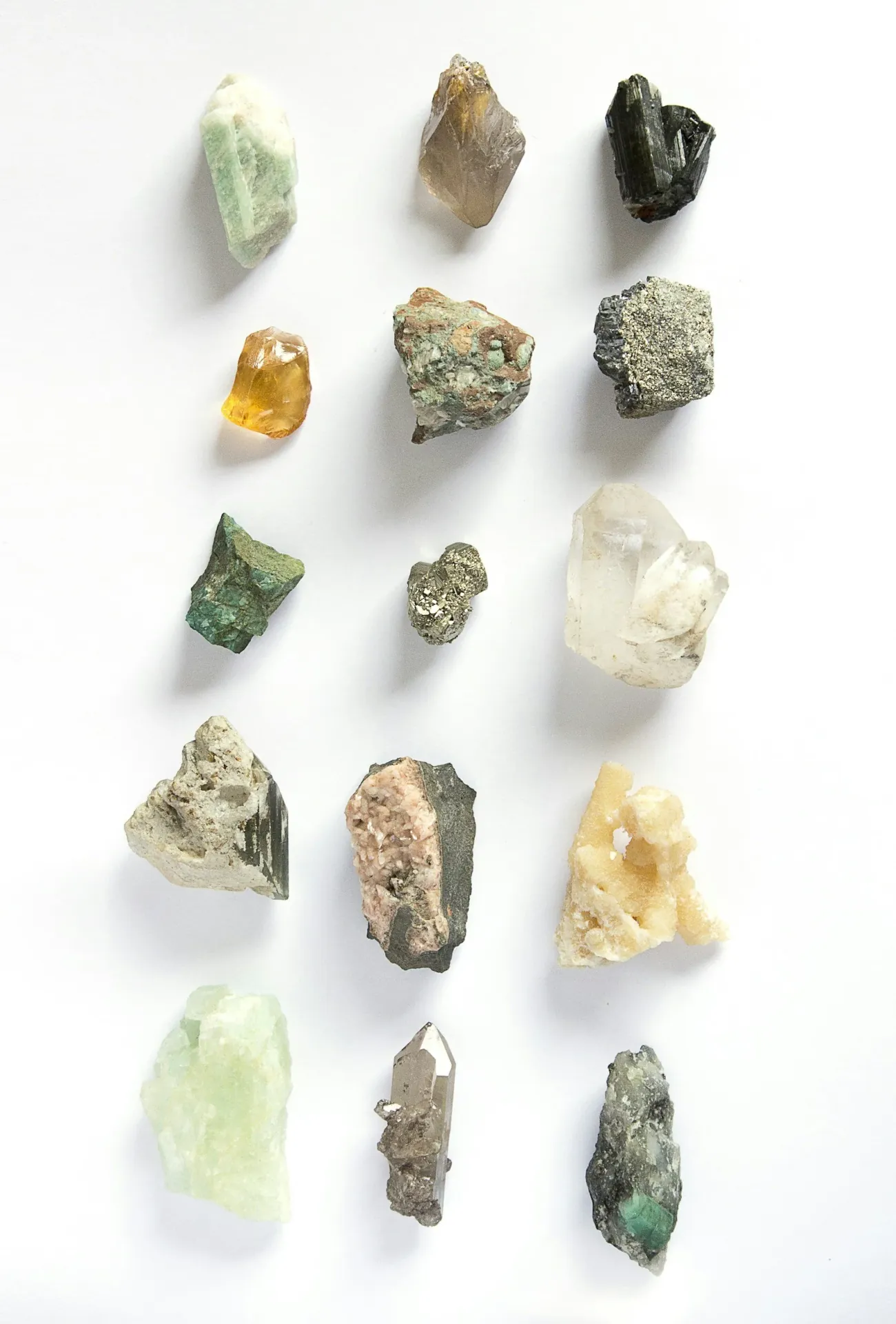 A grid of raw crystals and mineral specimens on white